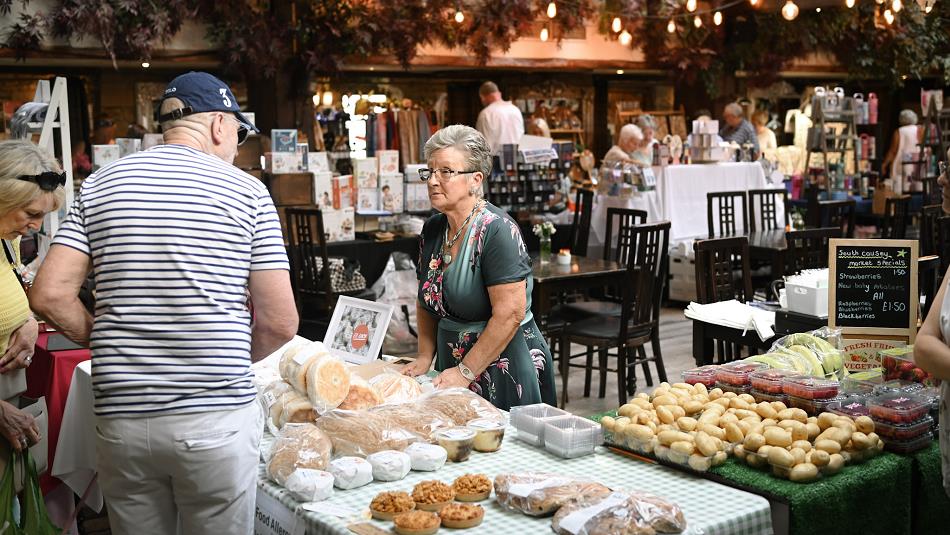 People buying food and drink from the Tuesday market at South Causey Inn