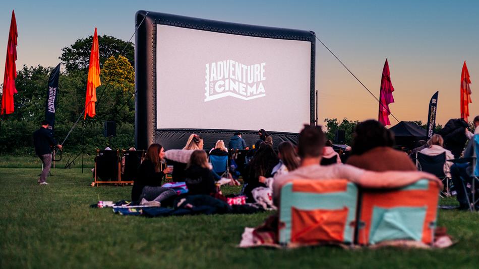 People enjoying Adventure Cinema at Raby Castle, Park and Gardens on a summer evening.