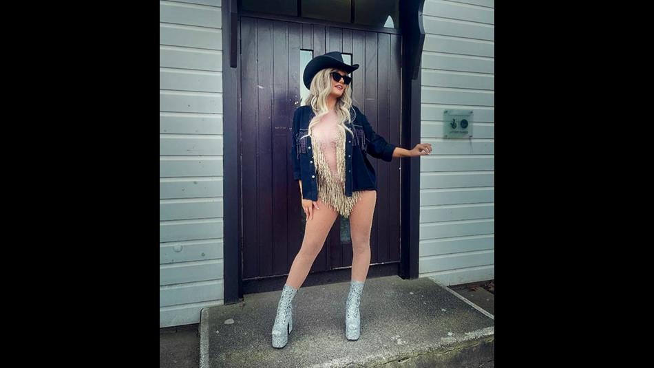 Taylor Swift lookalike in a cowgirl hat and silver platforms.