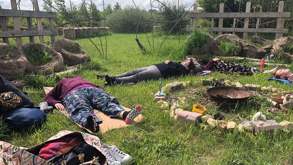People lying in the grass at Dalton Moor Farm enjoying a Mindful Morning