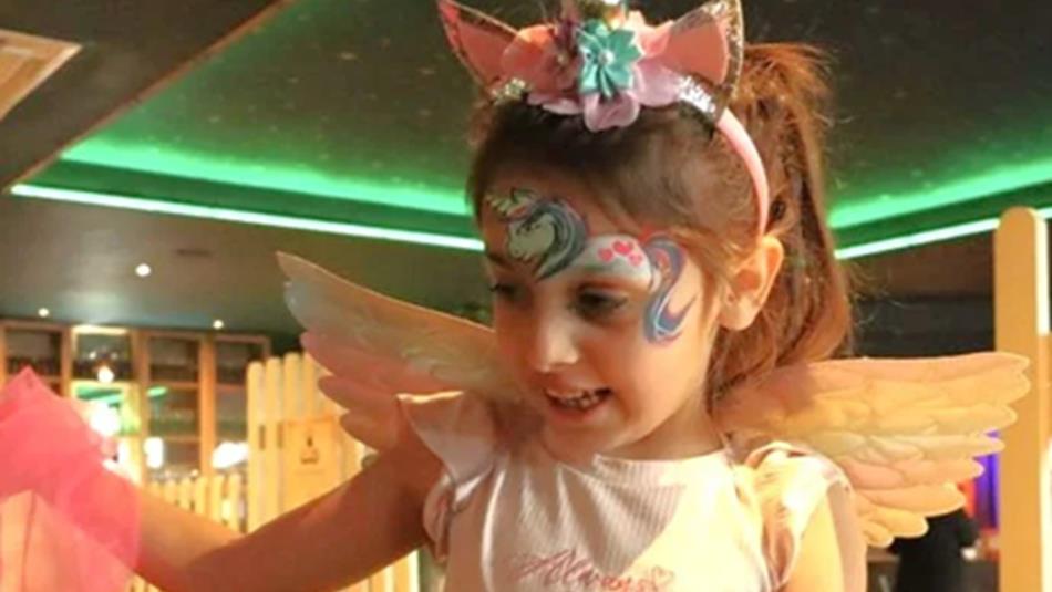 Little girl with fairy wings and a unicorn painted on her forehead