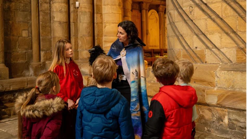 Children gather in a circle to enjoy family activities at Durham Cathedral.