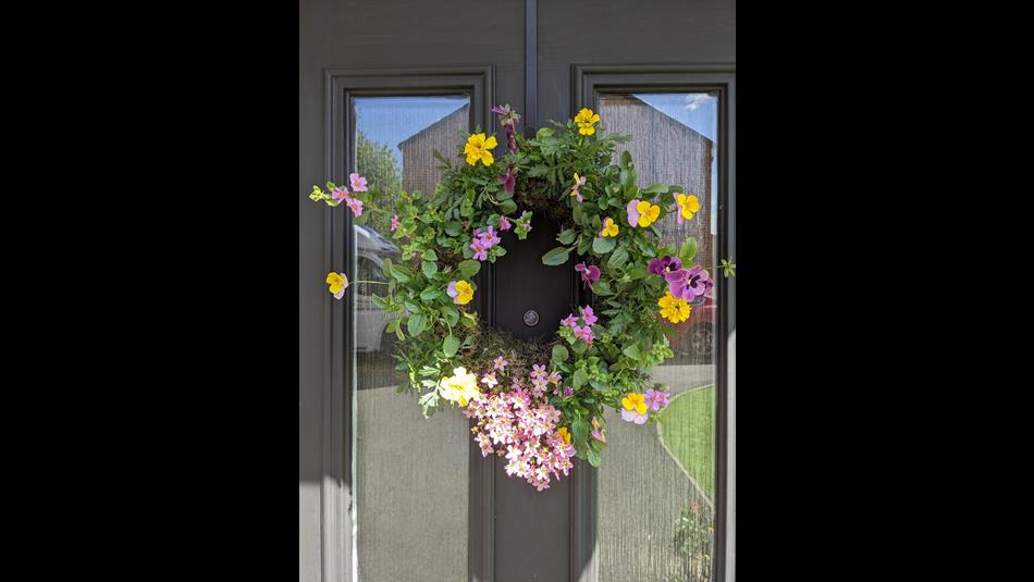 A colourful floral wreath on a door.