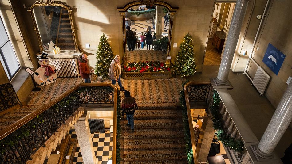 Staircase at The Bowes Museum decorated with Christmas trees.