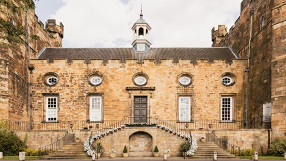 An entrance to Lumley Castle, two floral staircases leading to a door.
