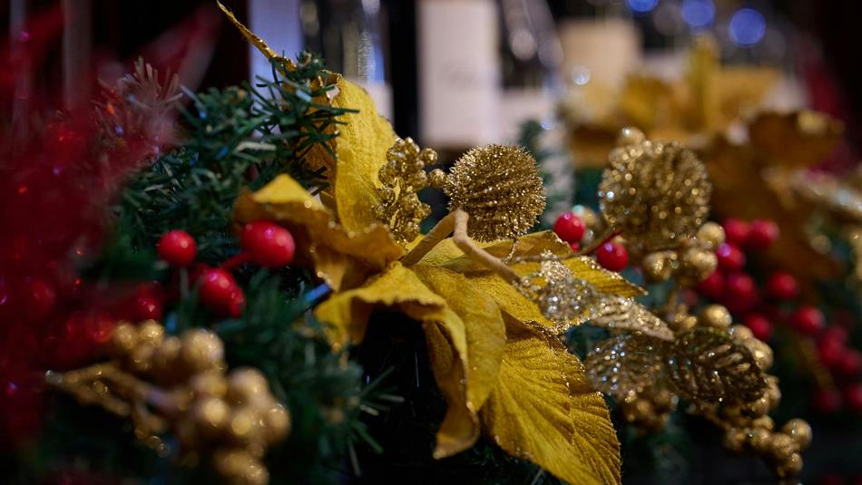Close up of a Christmas wreath with gold, green and red decorations.