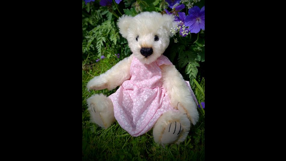 Traditional Teddy Bear in a pink dress.