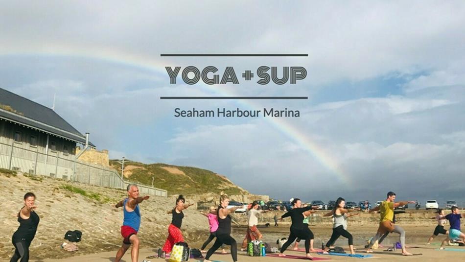 A Yoga and SUP session taking place under a rainbow at Seaham Harbour Marina.