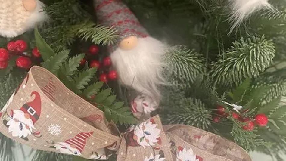 Festive greenery, decorated with a gonk and festive ribbon which has a pattern of snow flakes and gonks on it.