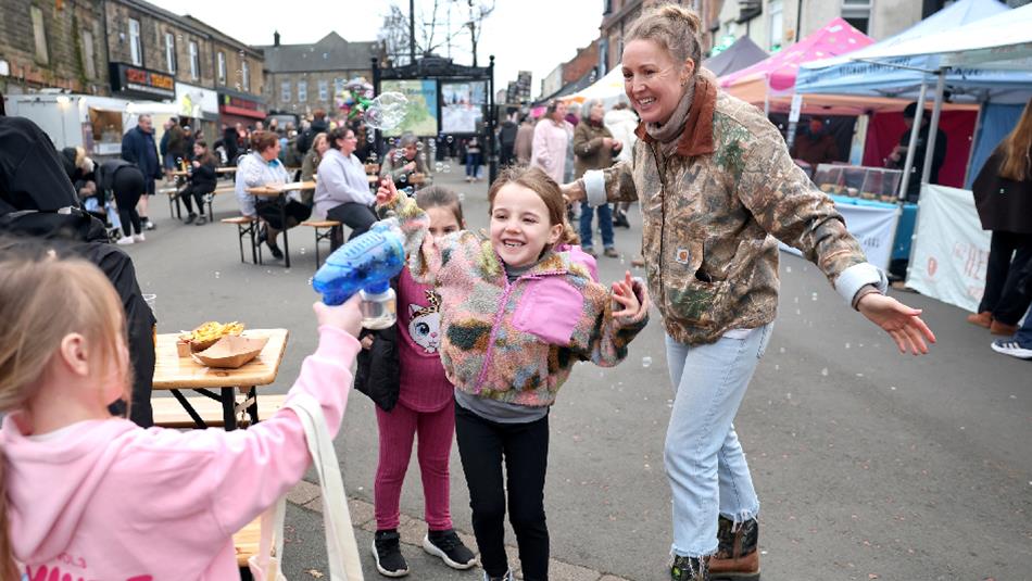 Adults and children enjoying the street food markets on Front Street, Stanley.