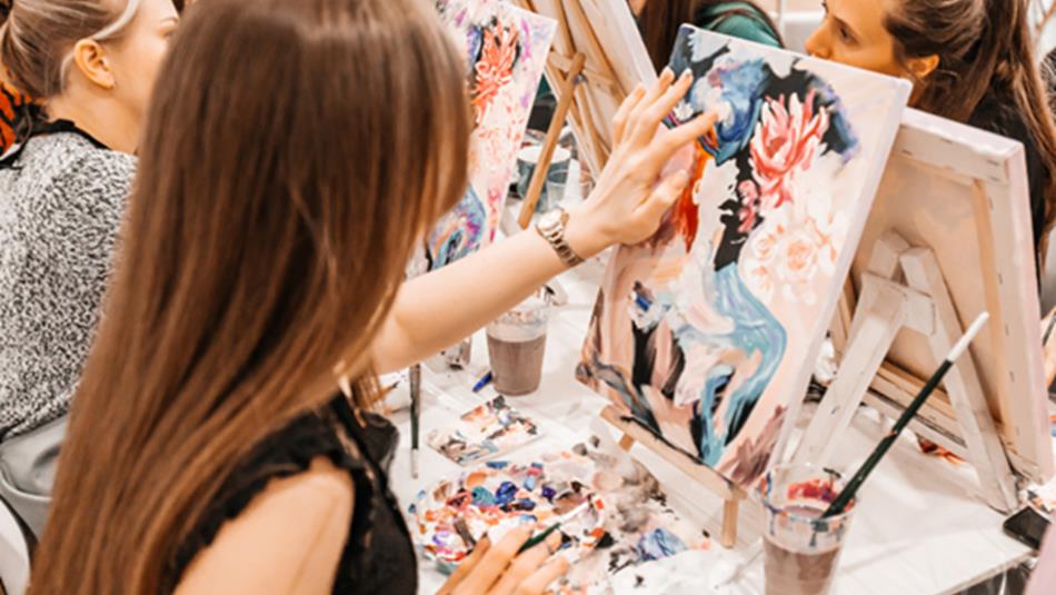 Artists painting colourful portraits.