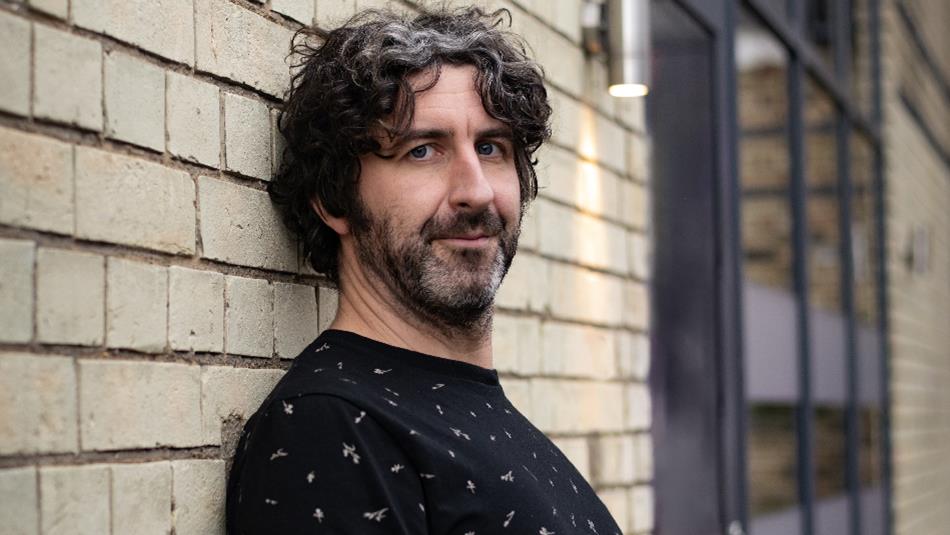 Mark Watson leaning against a wall
