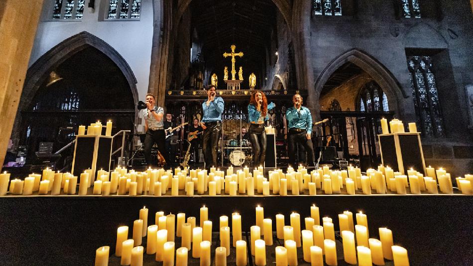 Singers performing surrounded by candles at Durham Cathedral.
