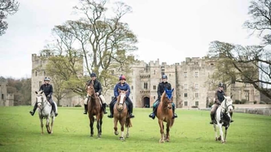 4 horses and riders in the grounds of Raby Castle.
