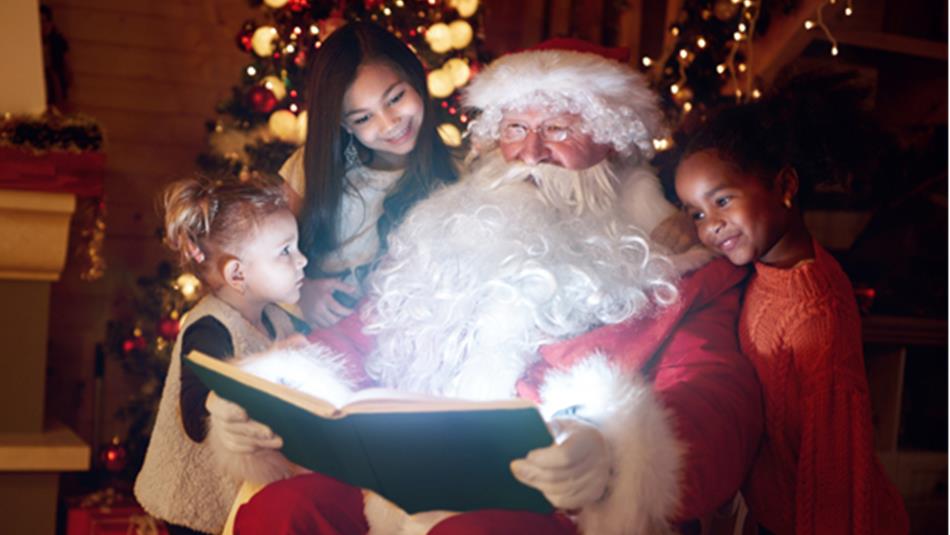 Santa reading three children a story.