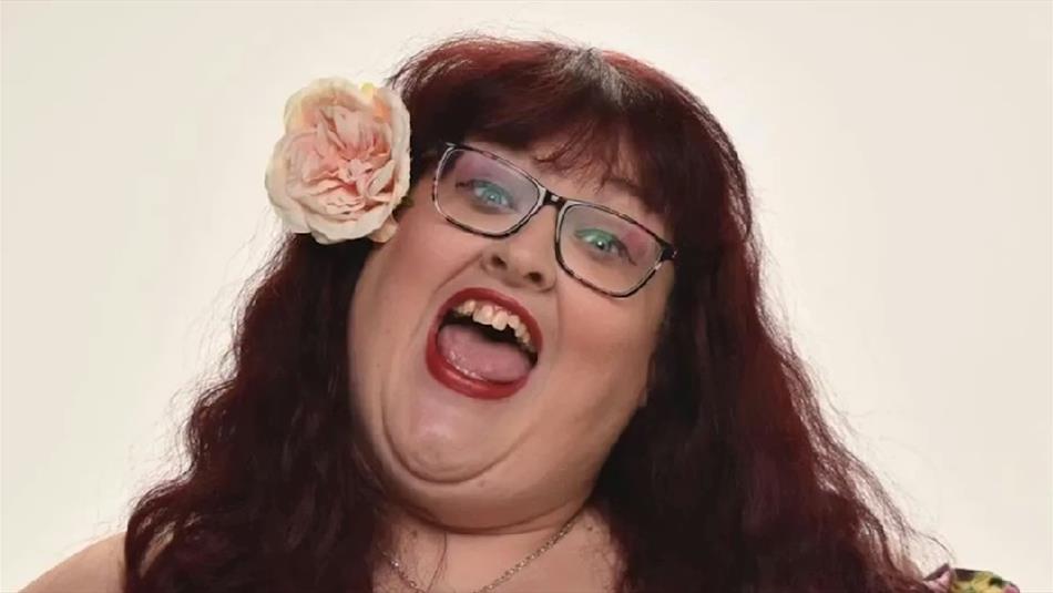 Headshot of Charlotte Forman with a flower in her hair (professional singer and comic).