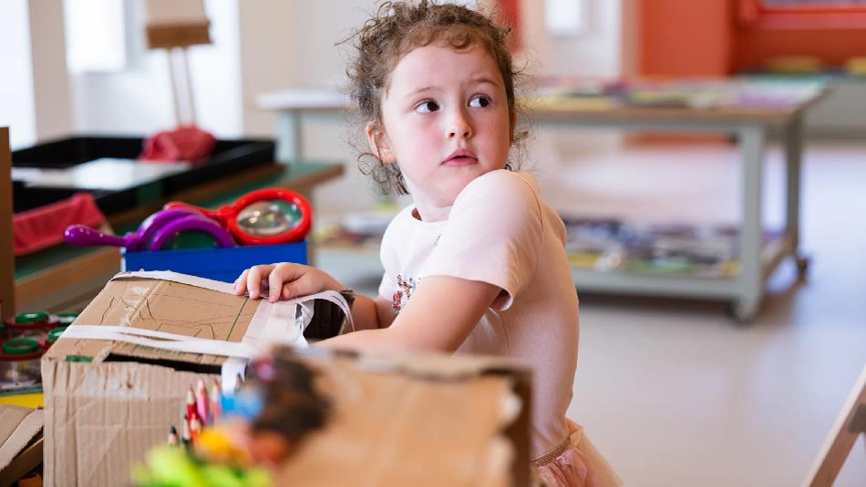 A child at The Bowes Museum opening a box.