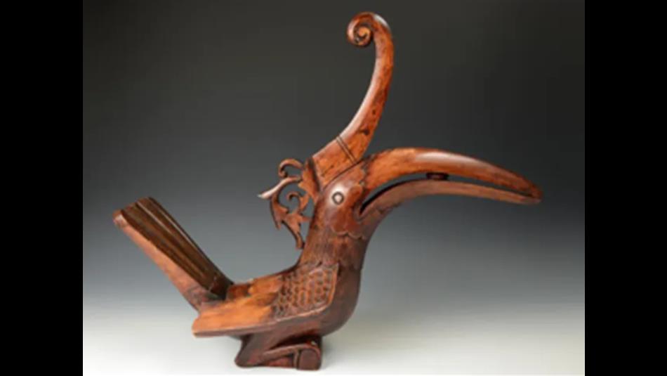 A wooden carving of a hornbill bird with a long, curved beak.