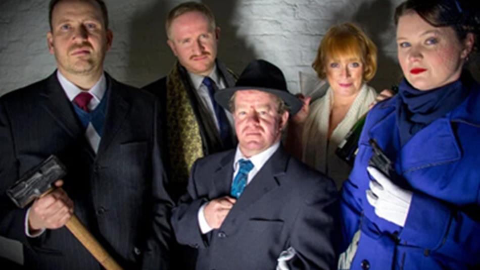 5 murder mystery participants in traditional clothing, one holding a hammer.