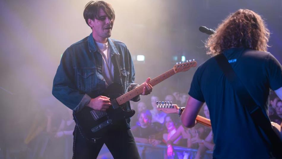 Jonny, lead singer of Sham Fender, and a band member performing to an audience.