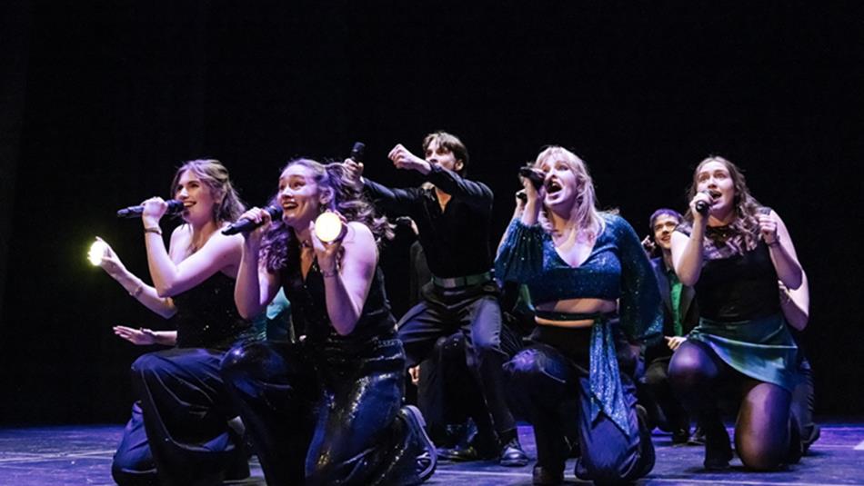 Northern Lights DU A cappella Group performing on stage.