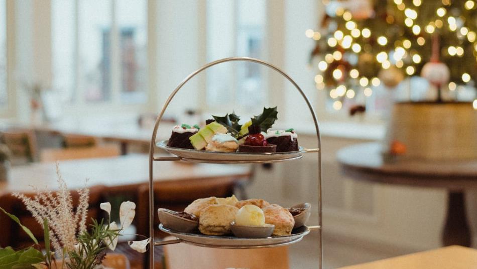 An arrangement of festive afternoon tea with a Christmas tree in the background on the right