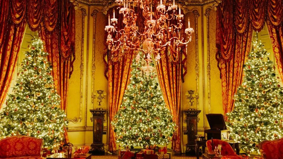 Three glowing Christmas trees in an elegant room at Raby Castle