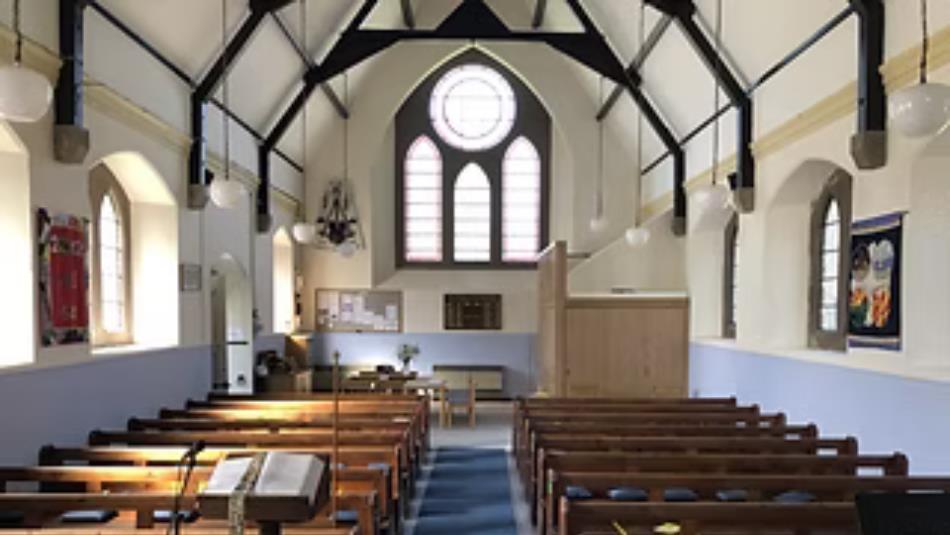 The interior of a church with pews and stained glass windows