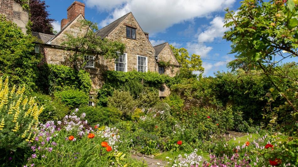 Lush greenery and gardens surrounding a stone building
