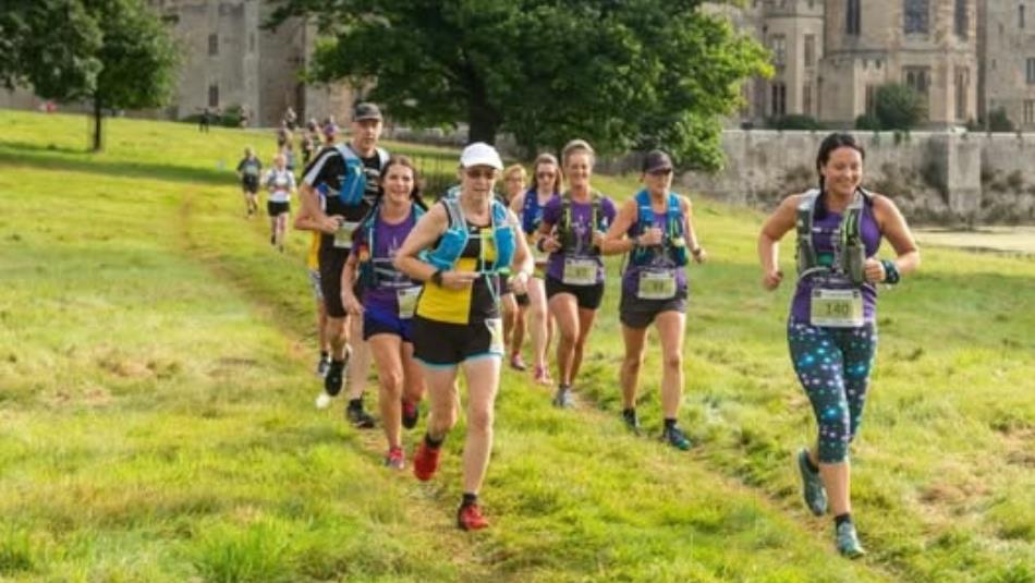 A group of people running across the field at Raby Castle