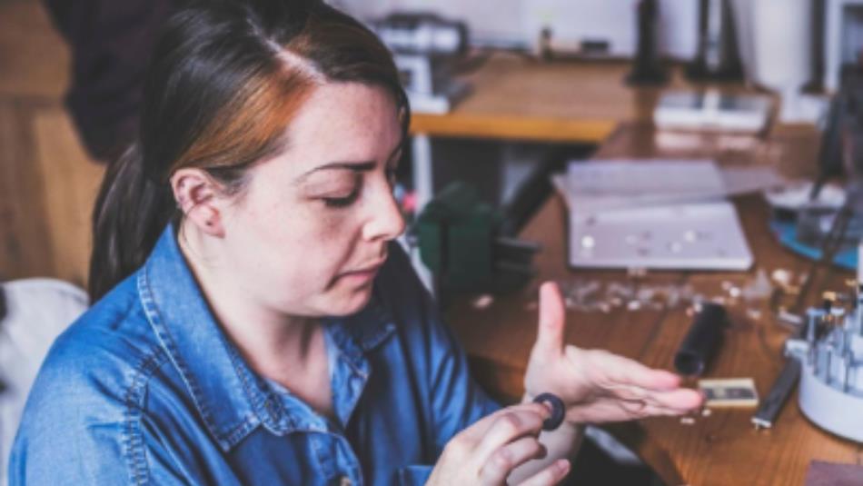 Person working in a workshop with a silver ring