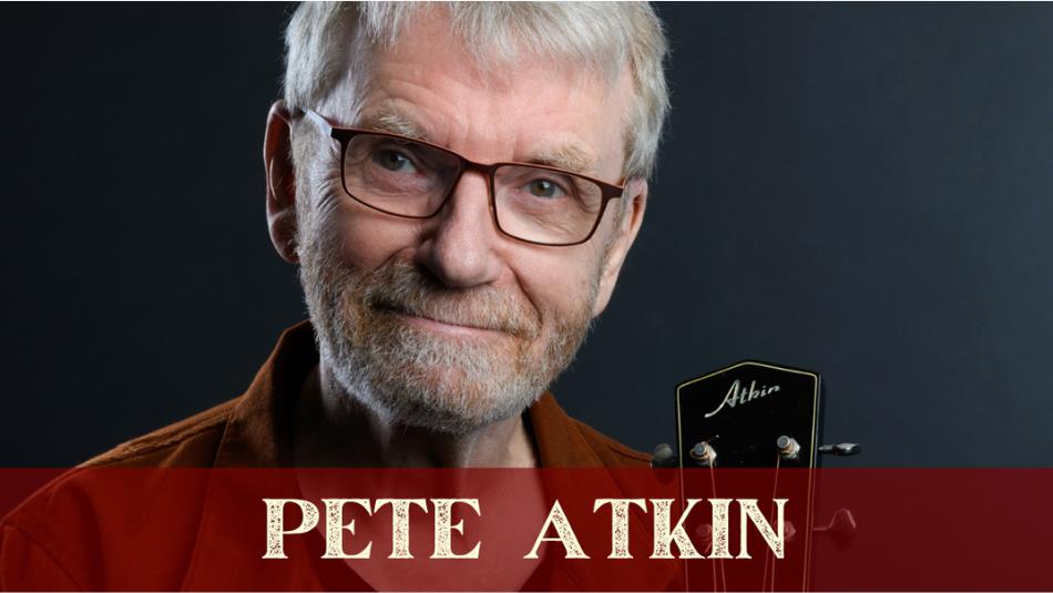 Musician Pete Atkin, smiling with his black guitar on a grey background