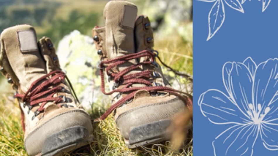 A pair of walking boots in the grass, on a blue floral background.