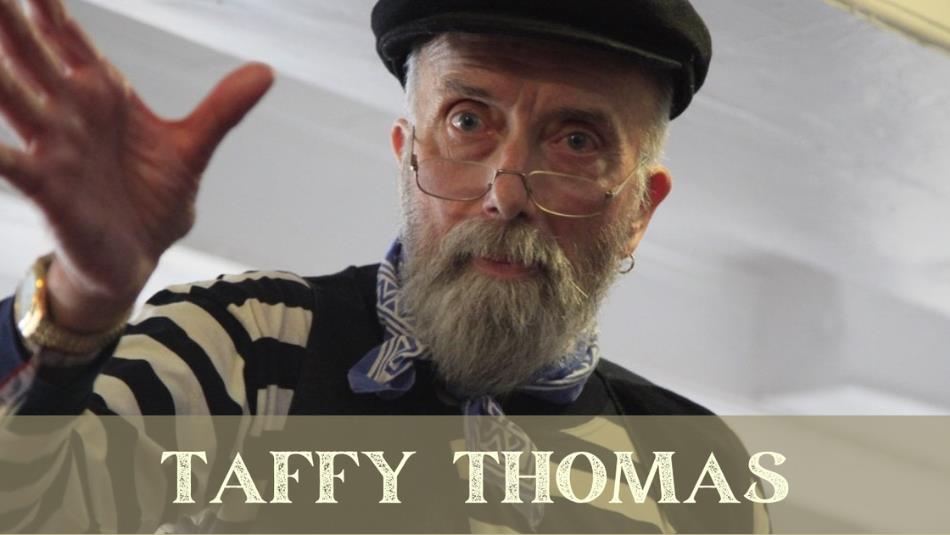 Person with glasses and a cap looking down at the camera, text 'Taffy Thomas.'