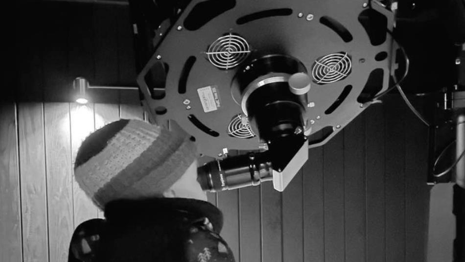 A young child looks through the eyepiece of a telescope.