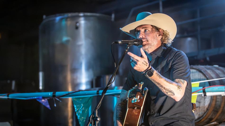 Jeremy McComb, a country singer in a white cowboy hat - regales the packed audience on his last visit to Steam Machine