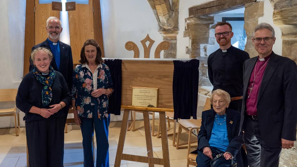 A group of 6 people smiling around a newly opened section of the Cuthbert Centre.