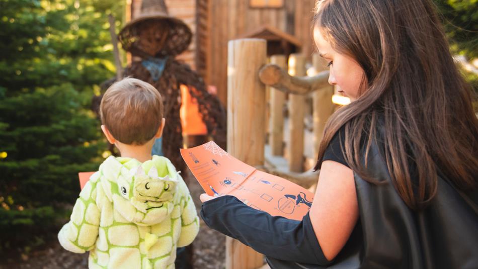 Children dressed up in fancy dress walking around a spooky outdoor trail.