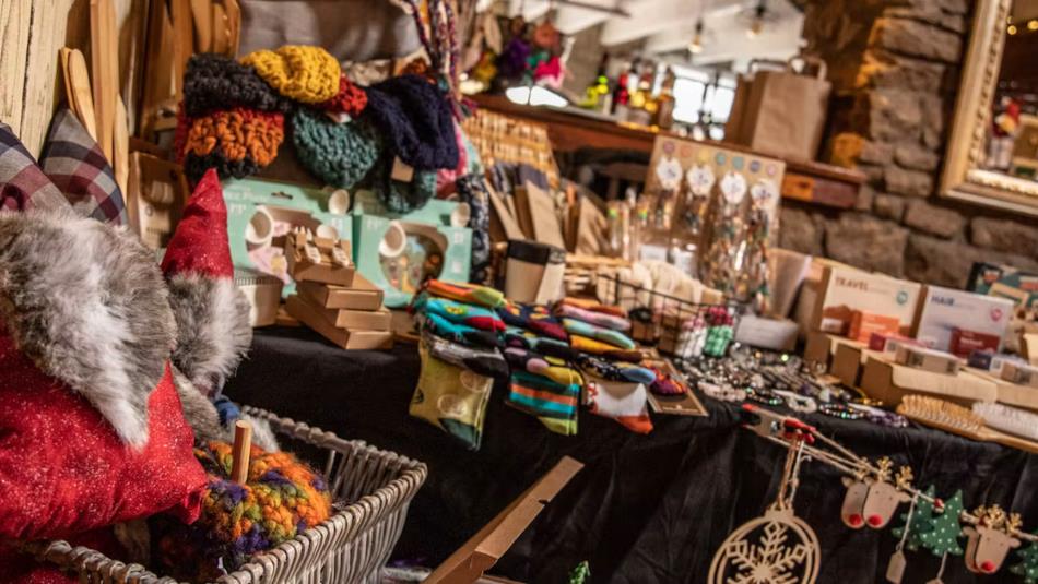 Stalls in a Christmas market, full of handmade goods and crafts.