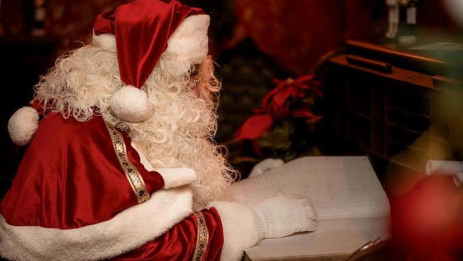 Santa reading a list in a festive grotto