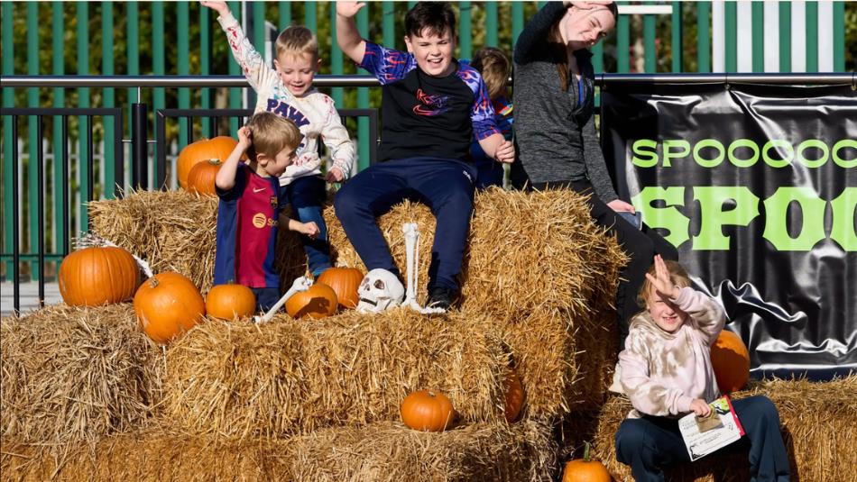Children sat on hay bales decorated with pumpkins and plastic skeletons.