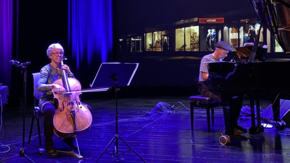 Two people on stage playing the cello and piano.
