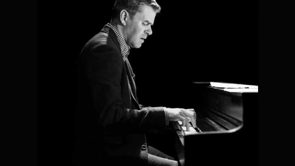 The side profile of a person playing the piano, the image is in black and white.