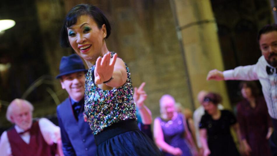 A group of people dancing in vintage clothing.