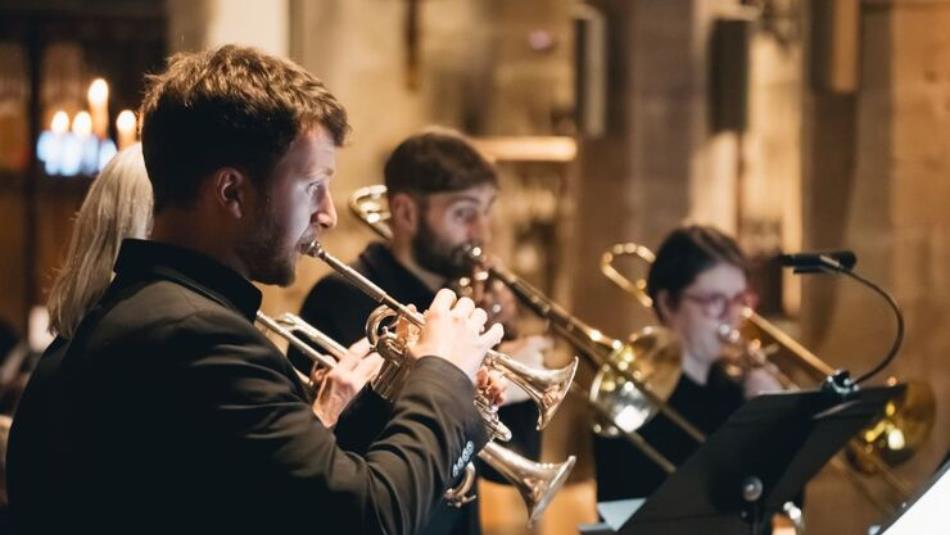Four musicians playing brass instruments.