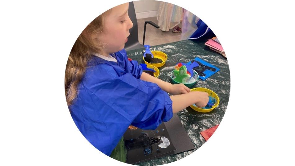 Small child playing with paint in a craft session.