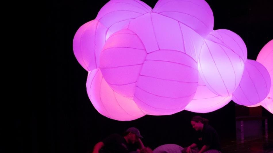 A cloud-like pink light installation in a dark room at The Light