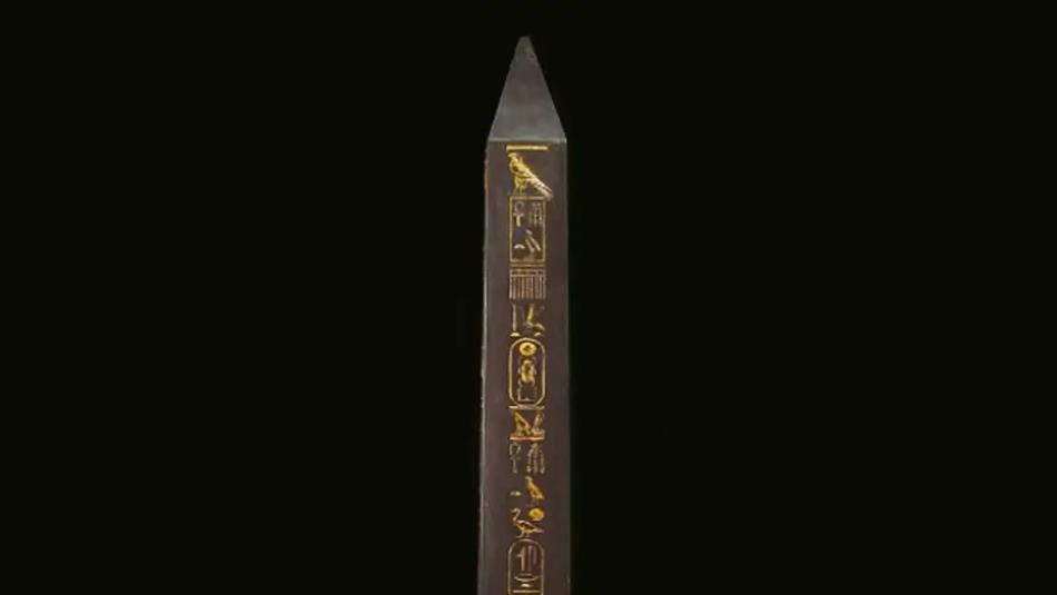 An Egyptian obelisk on a black background.