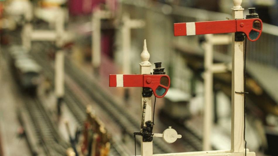 A miniature scale of two red train signals.