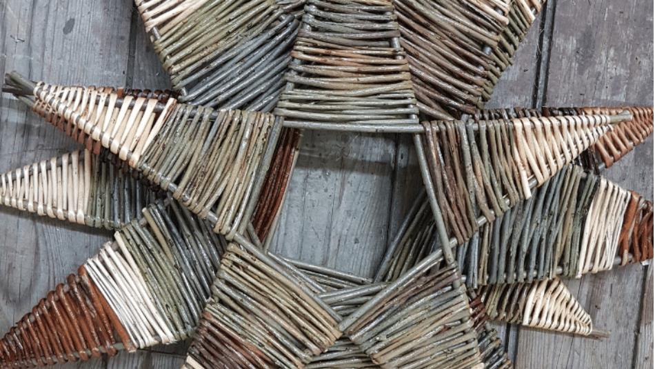 Decorative stars made from willow branches on a wooden floor.